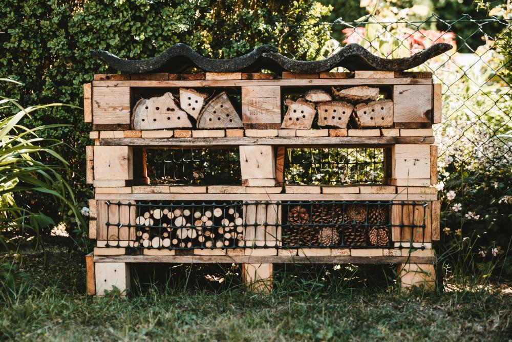 DIY Insect House using drilled in logs, sticks, and pallets