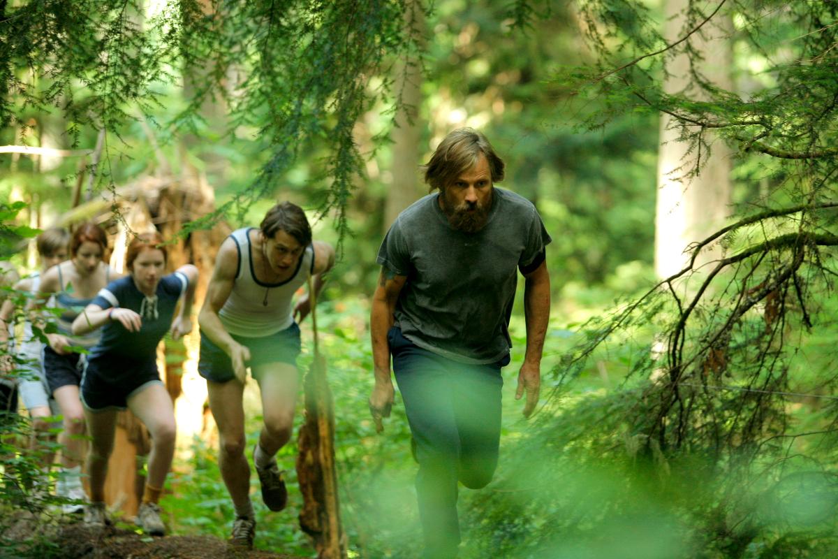 Film still showing the family running through the woods