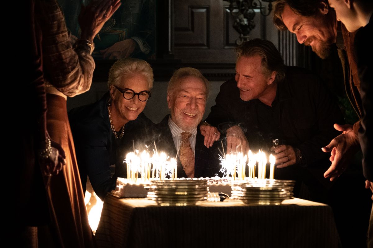 Film still: family gather round for the patriarch's blowing of the birthday candles
