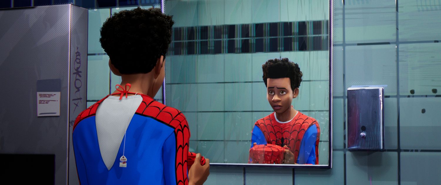 Film still: Miles Morales looks into the mirror as he wears the spider-man outfit