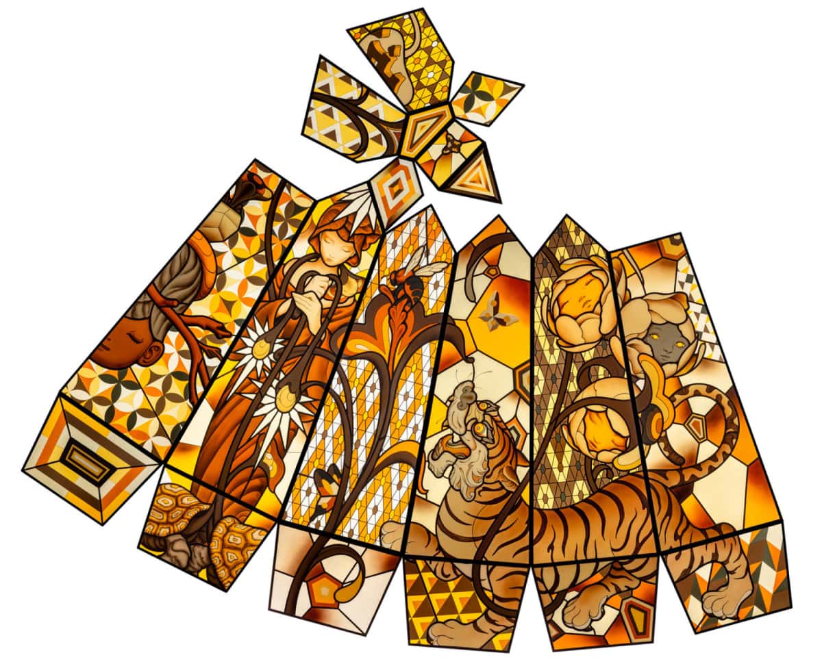 A glass sculpture laid out flat to see it in full. Filled with shades of amber. Shows the goddess Gaia, turtles, tiger and more.