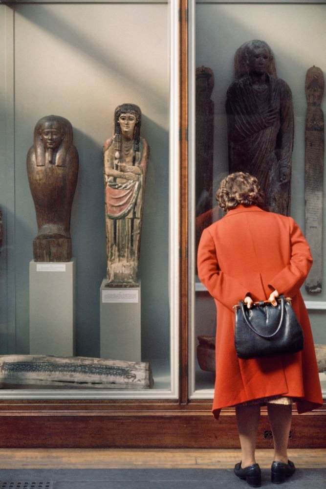 Photograph: A lady in a red coat looks at a window display.