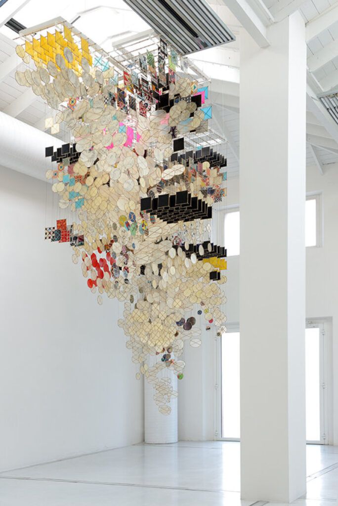 Photograph of Hashimoto's installation at Studio la Città, Verona, Italy. A large scale installation of paper kites are hanging down together from the ceiling, almost in the form of an icicle