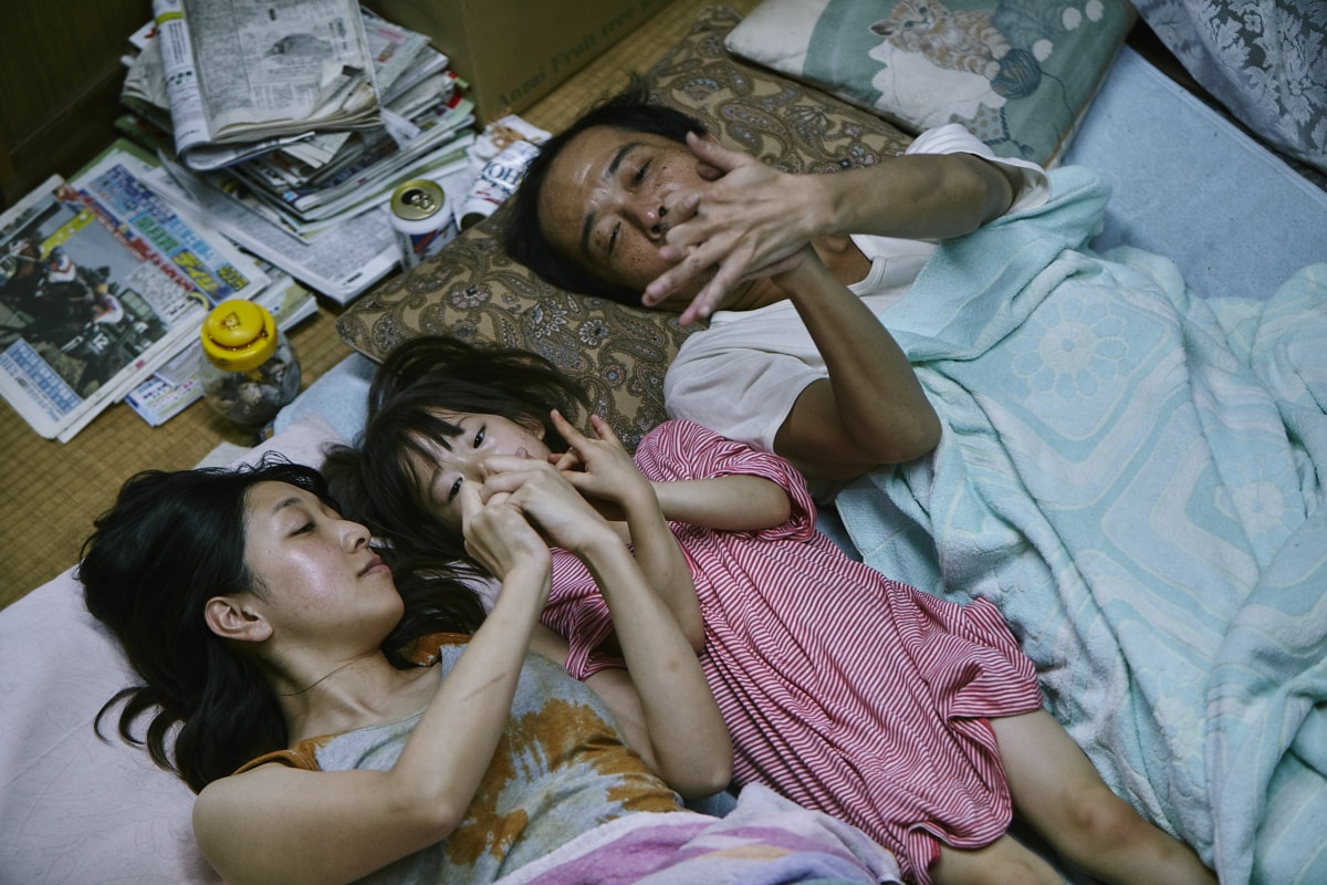 Film still: showing the Shibata father and Shibata mother play with the five year old girl they have 