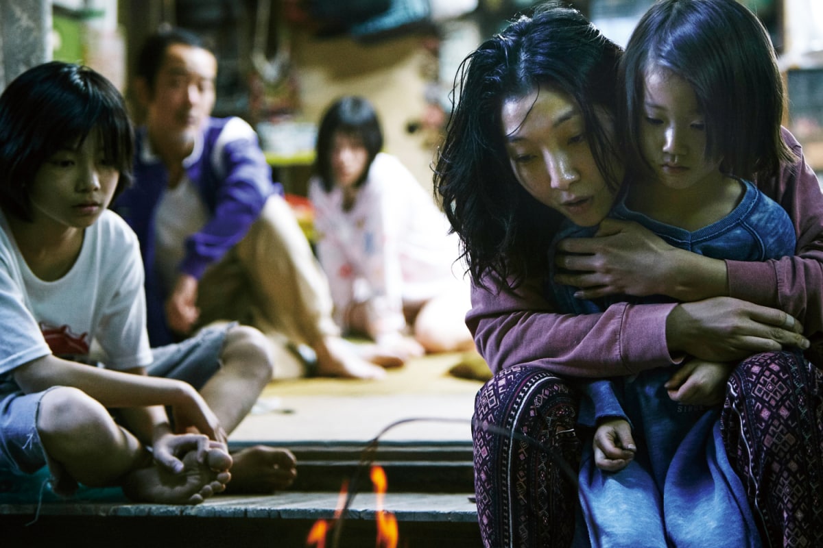 Film still: showing the family at home, with the Shibata mother and the little girl hugging at the forefront