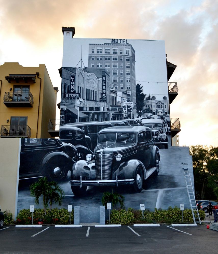 Black and white mural of São Paulo around the 1930s, featuring classic cars.