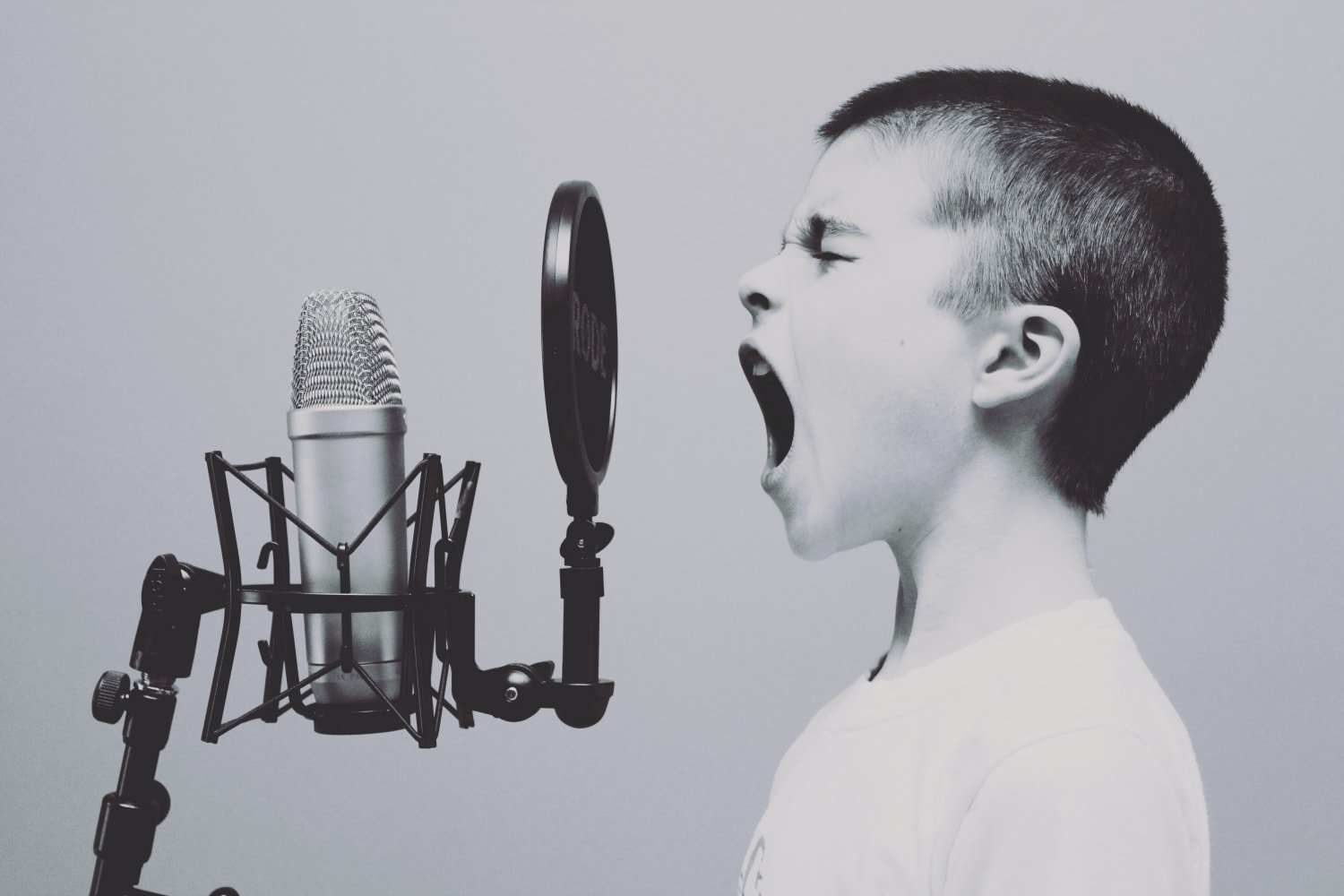 Young Boy Joyfully Shouting Into Studio Microphone