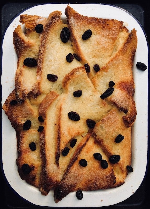 Bread and butter pudding fresh out of the oven, sprinkled in sugar and sultanas