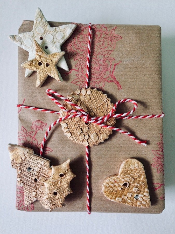Present gift wrapped with a scalloped tag holding the string, while alternative tags of stars, hearts and Christmas trees are shown to the side