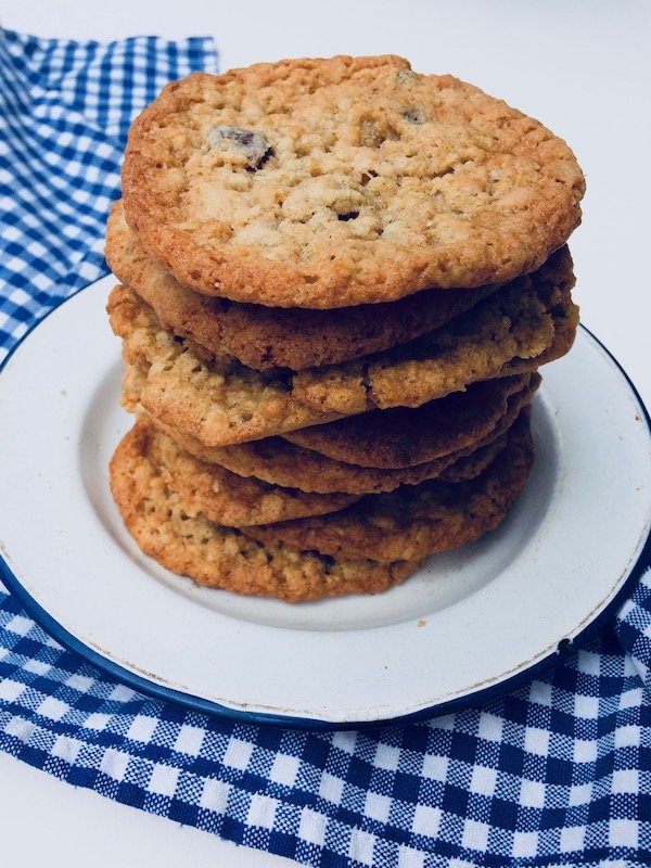 Stacked pile of oatmeal cookies on a blue and white checkered cloth