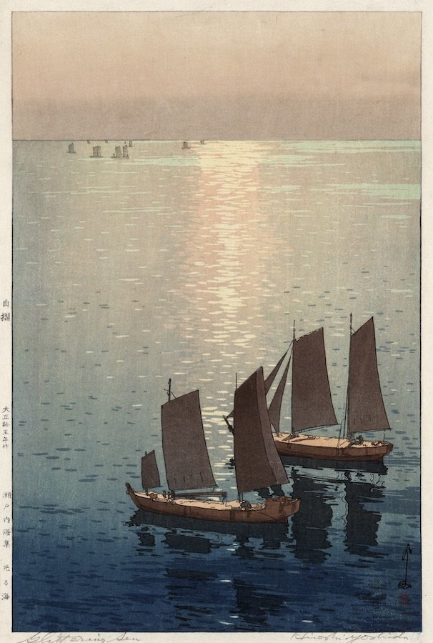 A woodblock print by Hiroshi Yoshida showing two old boats resting at sea, with the setting sun reflecting on the waves.