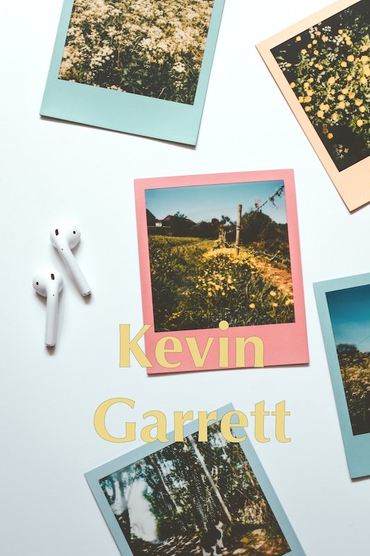 Photograph of a white backdrop with ear pods and a series of countryside polaroids.
