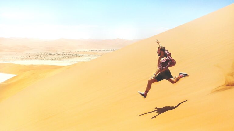 Picture of a man running wildly down a sand-dune